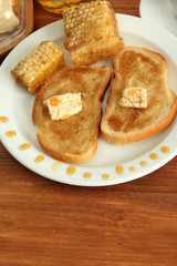 White bread toast with honey and cup of coffee on wooden table