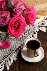 Beautiful pink roses in vase on wooden table close-up