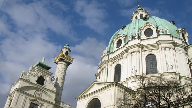 Towers of Karlskirche Church stand against floating clouds