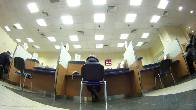 Client sit on chair and makes transaction in bank