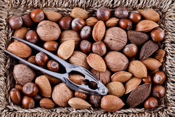 Whole nuts in a basket with nutcracker