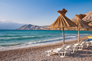 Sunshade and deck chair on beach at Baska in Krk - Croatia