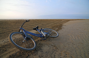 Fototapeta na wymiar Porzucony rower wzdłuż pustej plaży