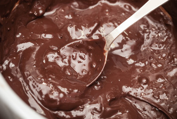 Hot melted chocolate in pan with spoon