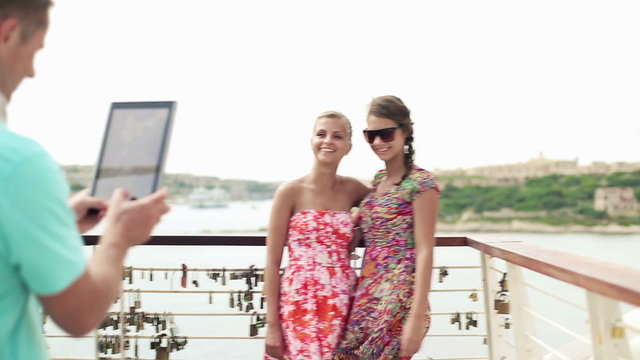 Friends taking photo with tablet computer on vacations