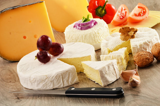Composition with different sorts of cheese on wooden table
