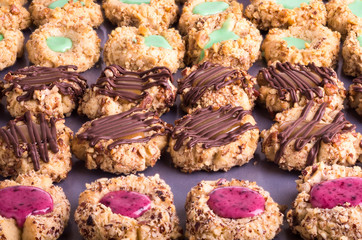 Rows of thumbprint cookies with nuts