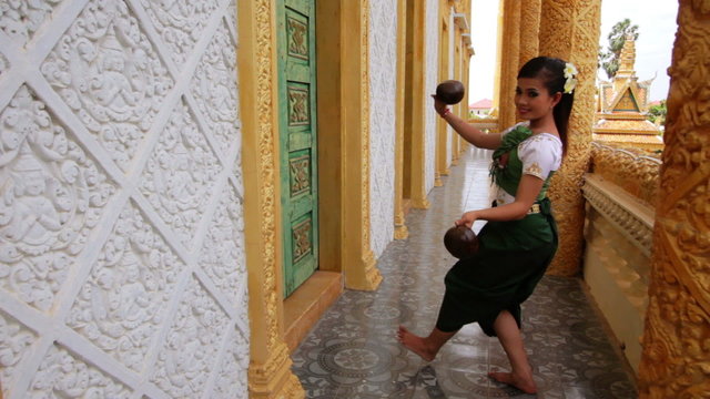 Beautiful Asian Girl performs coconut folk dance in temple