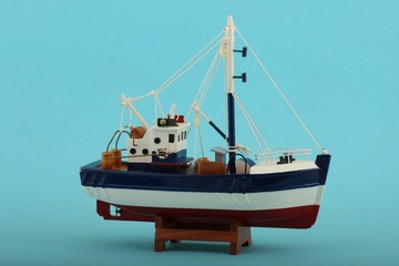 Fototapeta premium Fischerboot model mit blauem Hintergrund