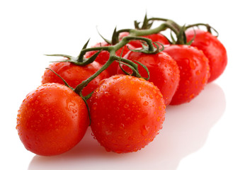 cherry tomatoes on a branch with drops isolated on white