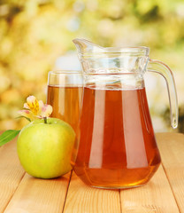 Full glass and jug of apple juice and apple