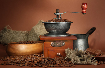 Obrazy na Plexi  Młynek do kawy, turek i ziarna kawy na brązowym tle