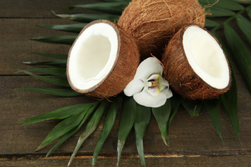 Fototapeta na wymiar Coconuts with leaves and flower, on grey wooden background