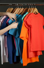 Obraz premium Variety of casual shirts on wooden hangers, isolated on black