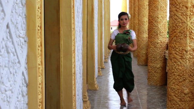 Beautiful Asian Girl performs coconut folk dance in temple