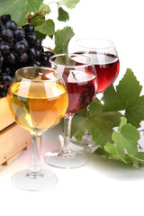 glasses of wine and assortment of grapes in wooden crate,