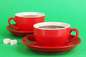 A red cups of strong coffee on green background