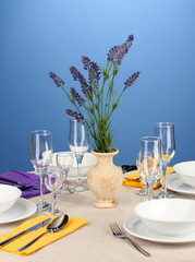 Table setting in violet and yellow tones on color  background