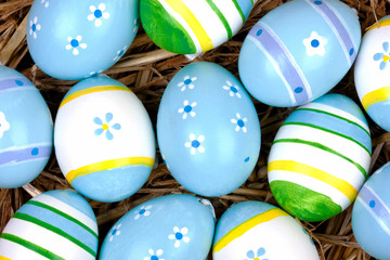 Fototapeta na wymiar malowane kolorowe jaja na Wielkanoc ukryte w gnie¼dzie słomy