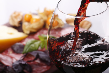 Gieten van wijn in glas en voedsel achtergrond
