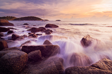 Waves and stones at the tropical sea sunset