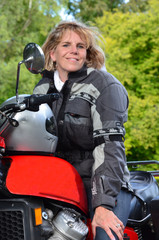 Blonde Frau mit Motorrad