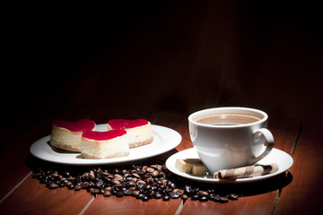 cake  on plate and cup of coffee on wooden table