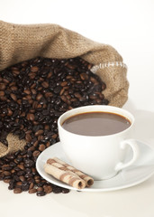 Cup of black coffee and beans isolated on white