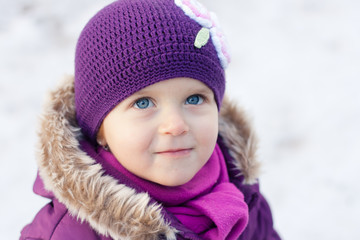 Close-up portrait of a little girl outdoors on a winter day