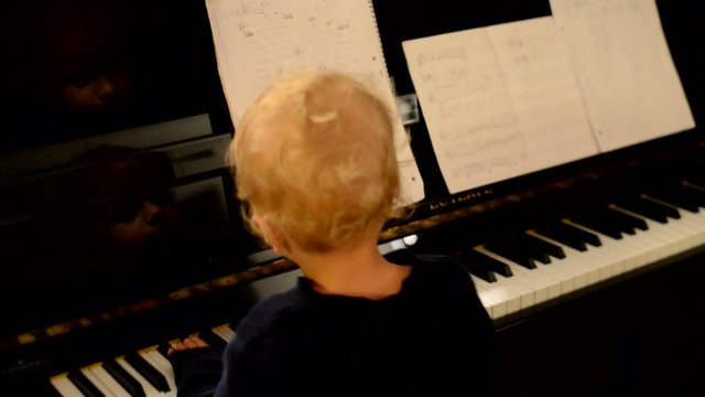 Kleiner Junge spielt Klavier
