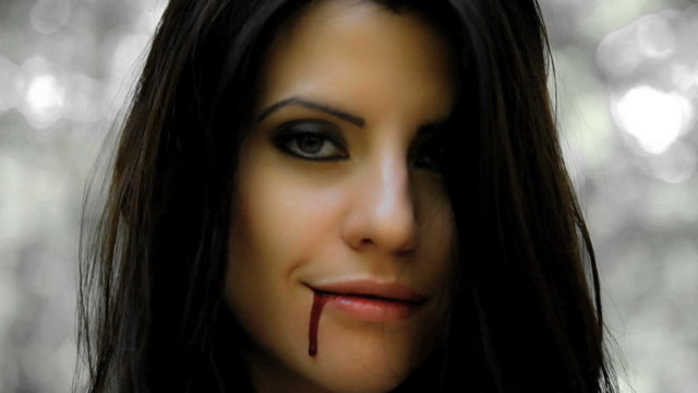 Happy vampire woman with blood