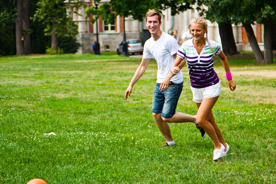 man and woman playing football in the park