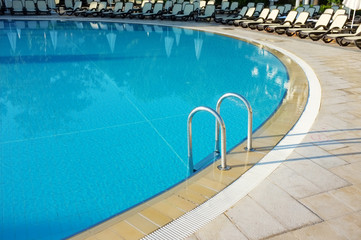 Obraz na płótnie Canvas Basen hotelowy ze słonecznymi refleksami.