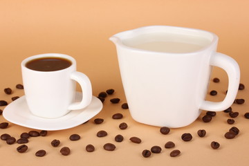 A cup of strong coffee and sweet cream on beige background