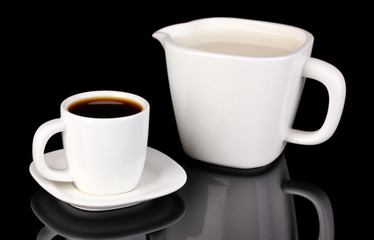 A cup of strong coffee and sweet cream isolated on black