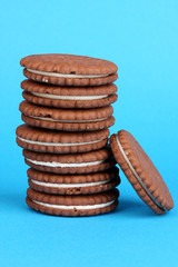 Chocolate cookies with creamy layer on blue background