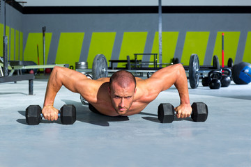 Fototapeta premium Gym man push-up strength pushup exercise with dumbbell