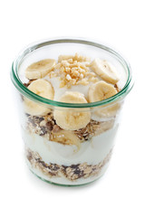Glas vor weißem Hintergrund mit Bananen Müsli.