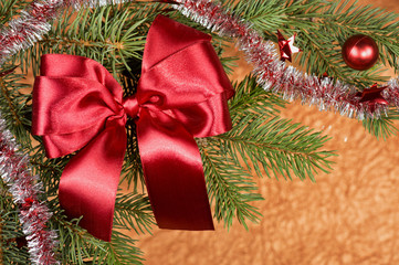 fir branches with red bow on golden background