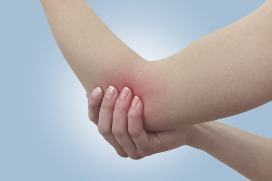 Acute pain in a woman elbow. Female holding hand to spot of elbo