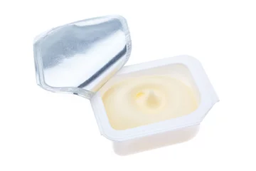 Fototapeten Open plastic packages of butter. On a white background. © sergojpg