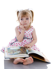 dreaming baby girl reading a book. isolated on white