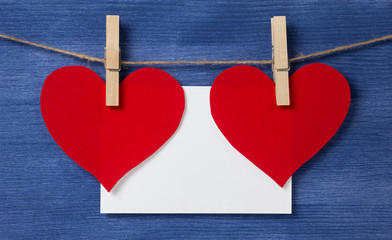Two paper hearts and card hanging on a rope