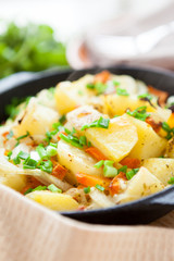 potatoes with green onions baked in a pan