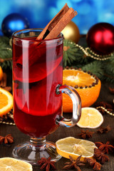 Fragrant mulled wine in glass with spices and oranges around