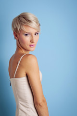 Fototapeta premium Young woman portrait over blue background.