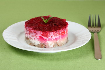 Traditional Russian salad with herring on a green napkin