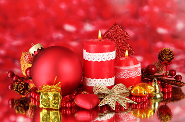 Red candle with christmas decoration on bright background