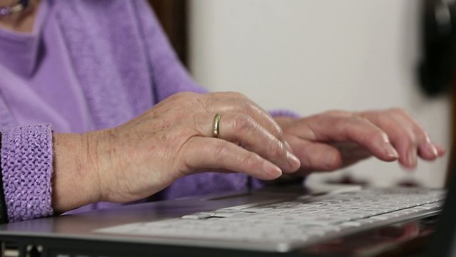 Rentnerin tippt an Laptop