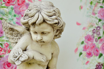 Vintage cupid sculpture with floral background